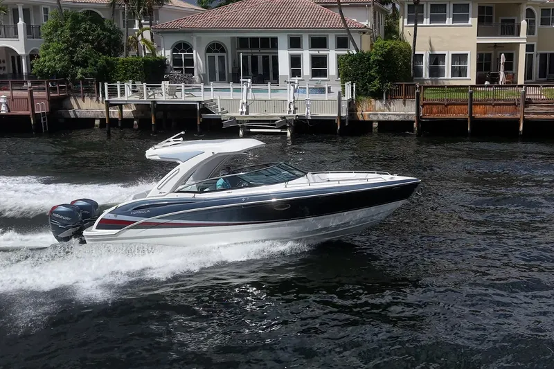 Slide: The Image of 2022 Formula 310 Bowrider OB cruising on water near waterfront homes. - 28