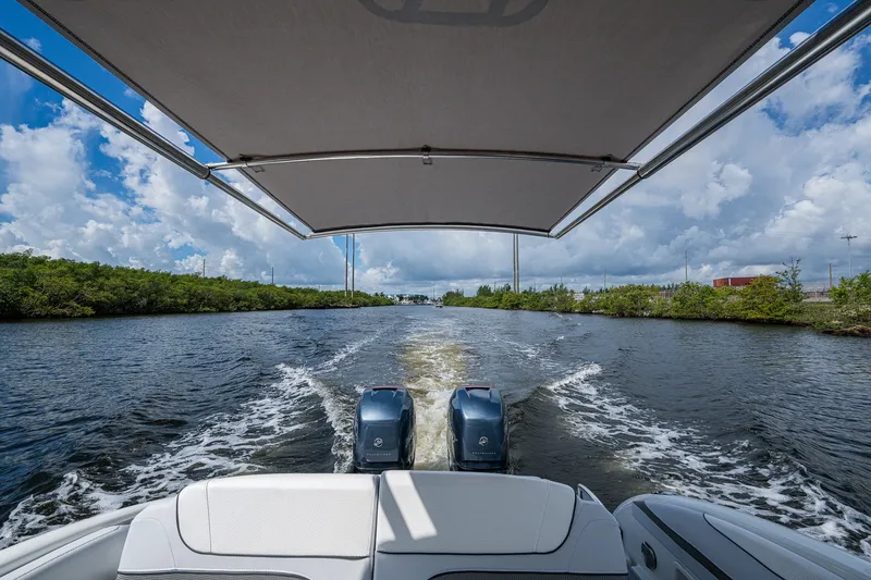 Slide: The Image of 2022 Formula 310 Bowrider OB cruising on a scenic waterway under a clear sky. - 52
