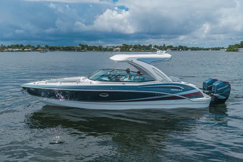 Slide: The Image of 2022 Formula 310 Bowrider OB cruising on a calm lake under a cloudy sky. - 10