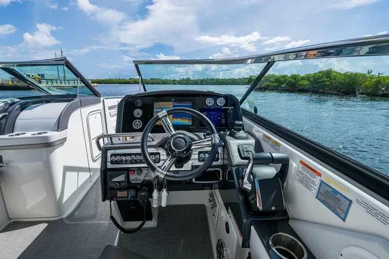 Slide: The Image of Cockpit view of 2022 Formula 310 Bowrider OB, featuring modern controls and scenic waterway. - 57