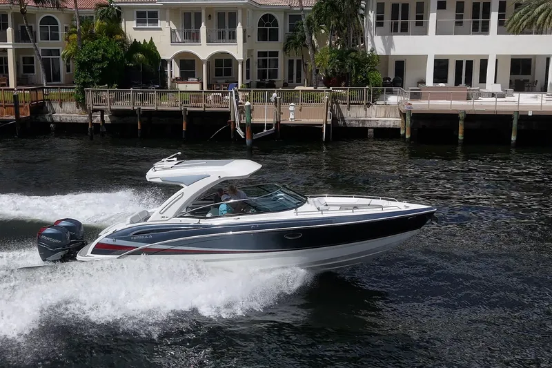 Slide: The Image of 2022 Formula 310 Bowrider OB cruising on water near waterfront homes. - 29