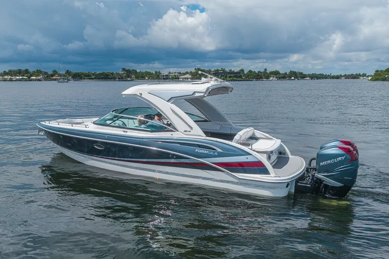 Slide: The Image of 2022 Formula 310 Bowrider OB cruising on a calm lake under a cloudy sky. - 11