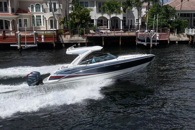 Slide: The Image of 2022 Formula 310 Bowrider OB cruising on water near waterfront homes. - 27