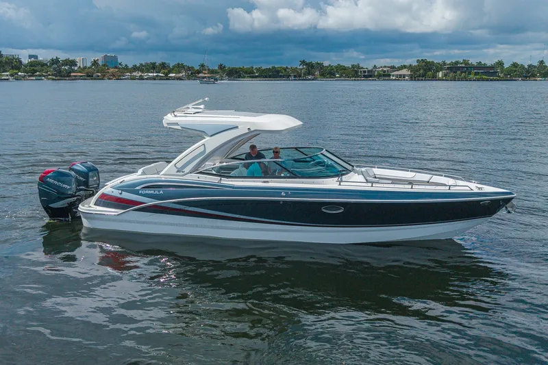 Slide: The Image of 2022 Formula 310 Bowrider OB boat on calm water, featuring sleek design and powerful outboard engines. - 3