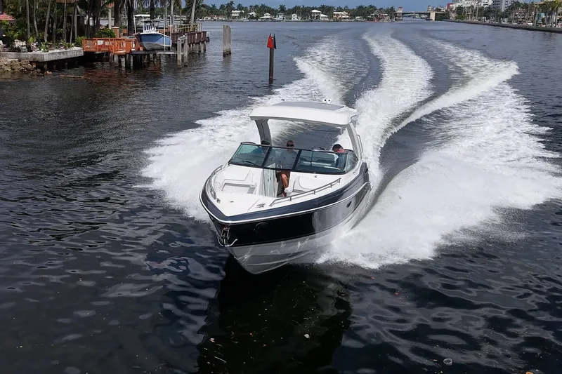 Slide: The Image of 2022 Formula 310 Bowrider OB cruising on a scenic waterway, creating a dynamic wake. - 22
