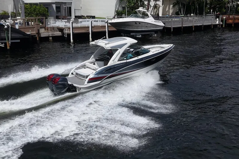 Slide: The Image of 2022 Formula 310 Bowrider OB cruising on a waterway near docks. - 74