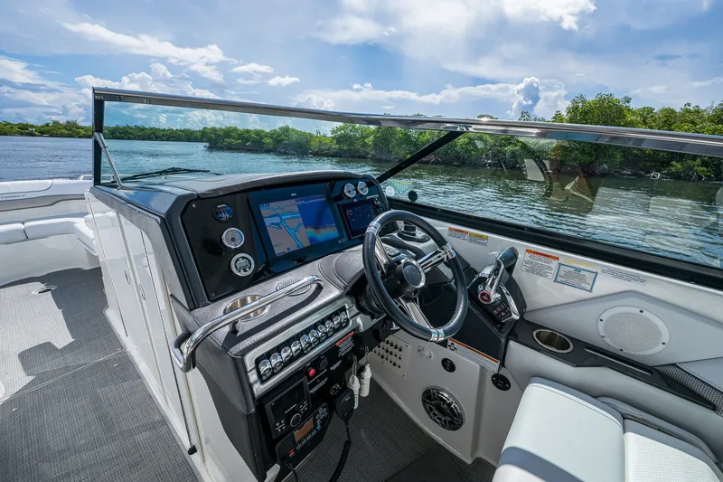 Slide: The Image of 2022 Formula 310 Bowrider OB cockpit with modern controls and scenic water view. - 56