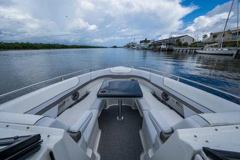 Slide: The Image of 2022 Formula 310 Bowrider OB interior with seating and table on a scenic waterway. - 70