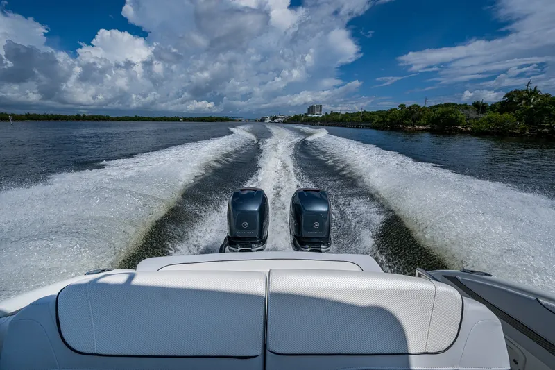 Slide: The Image of 2022 Formula 310 Bowrider OB cruising on a scenic waterway under a vibrant blue sky. - 64