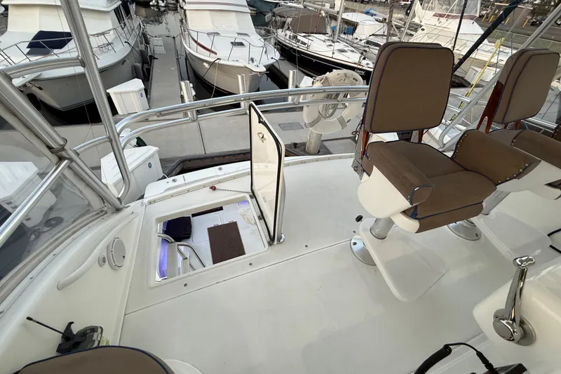 Slide: The Image of 2002 Viking 48 Convertible yacht deck with open hatch and docked boats. - 22