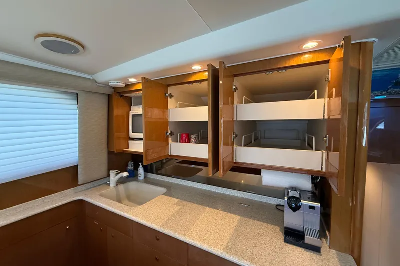 Slide: The Image of Luxurious kitchen interior of 2002 Viking 48 Convertible yacht with open cabinets. - 32