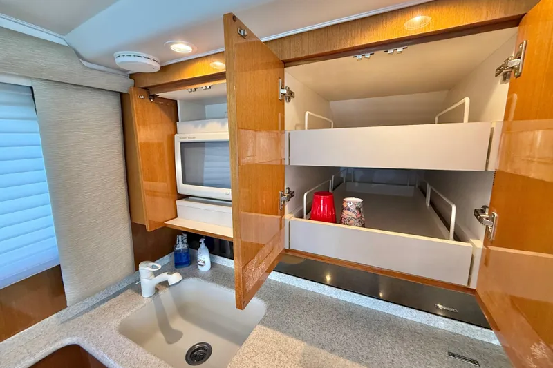 Slide: The Image of Kitchen area of a 2002 Viking 48 Convertible yacht with open cabinets and sink. - 34