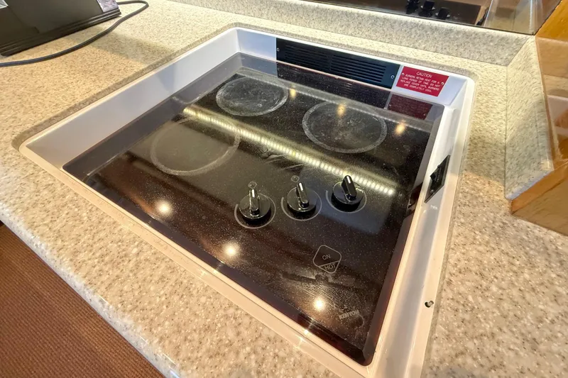 Slide: The Image of Stovetop on 2002 Viking 48 Convertible yacht, featuring three control knobs. - 36