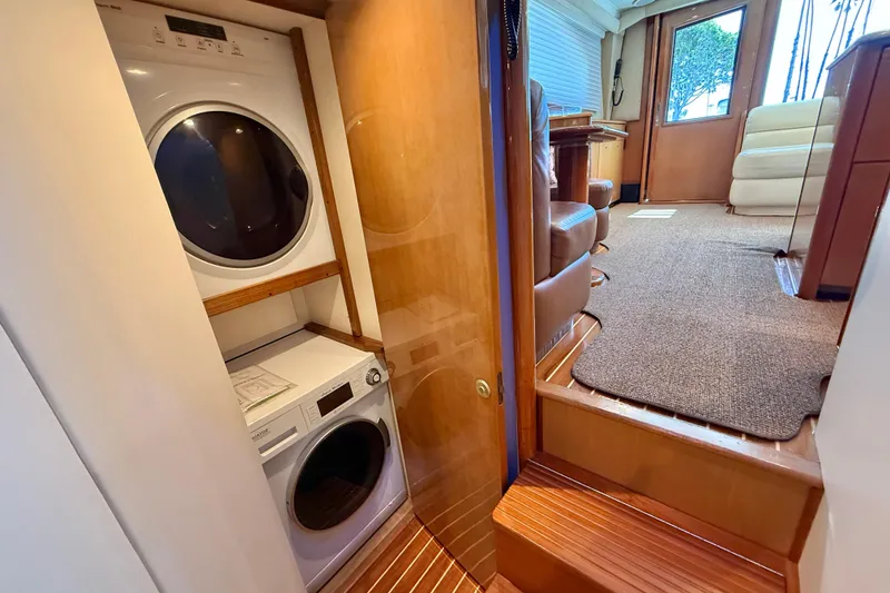Slide: The Image of Laundry area inside 2002 Viking 48 Convertible yacht, featuring stacked washer and dryer. - 39