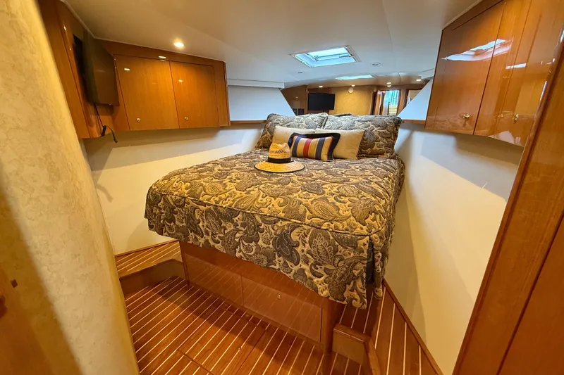 Slide: The Image of Luxurious bedroom interior of 2002 Viking 48 Convertible yacht with elegant bedding and wood finish. - 40