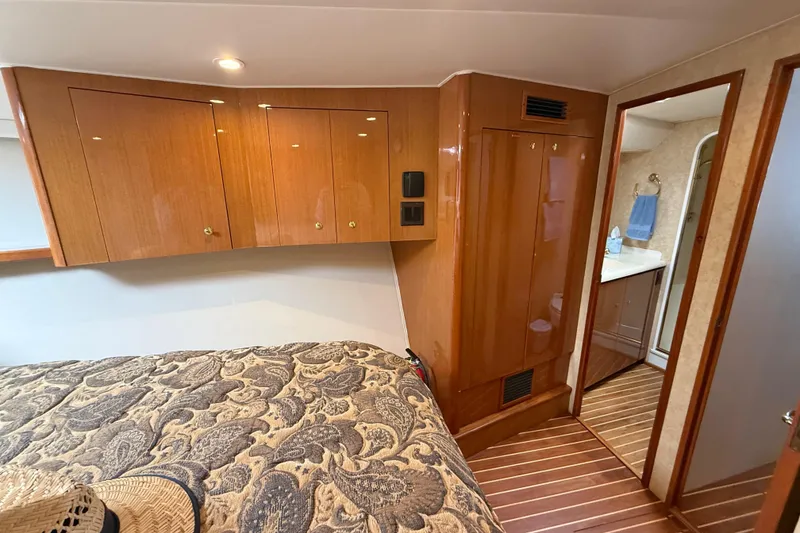 Slide: The Image of Luxurious cabin interior of 2002 Viking 48 Convertible yacht with wood finishes and patterned bedding. - 42