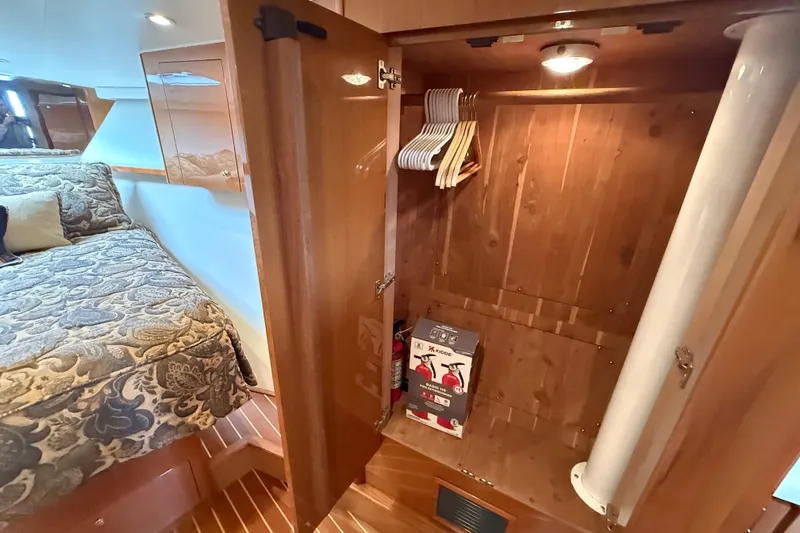 Slide: The Image of Interior of 2002 Viking 48 Convertible yacht with open wooden closet and bed. - 43