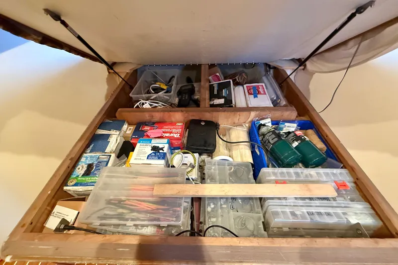 Slide: The Image of Storage compartment on a 2002 Viking 48 Convertible, filled with tools and supplies. - 51