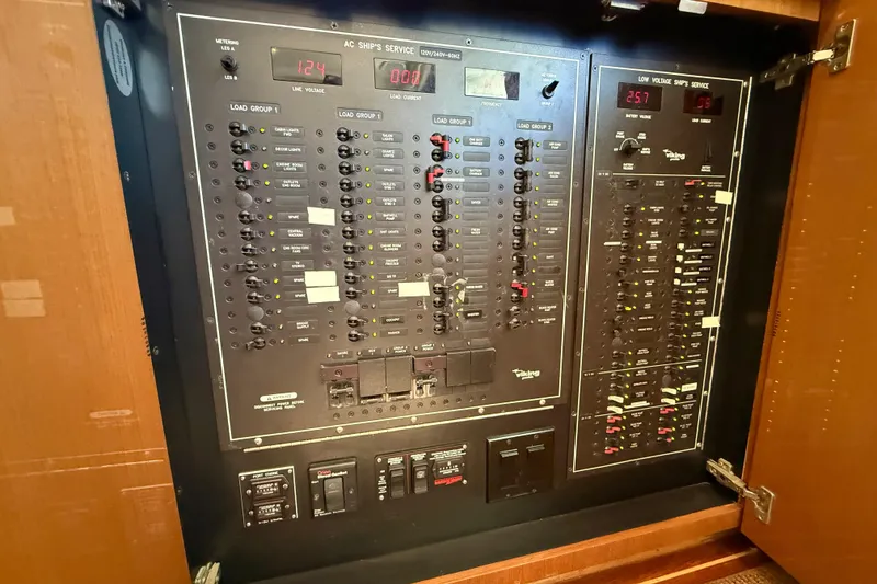 Slide: The Image of Electrical panel of a 2002 Viking 48 Convertible yacht, showcasing switches and meters. - 52
