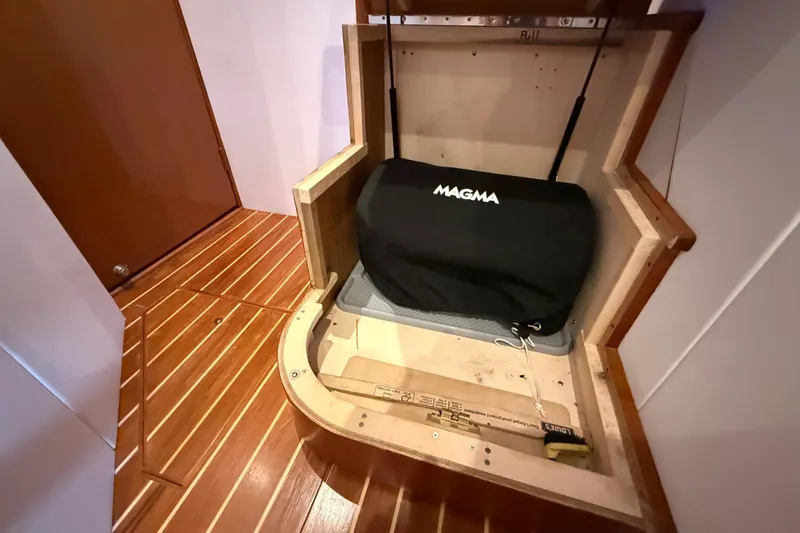 Slide: The Image of Interior of 2002 Viking 48 Convertible with Magma grill storage on wooden flooring. - 53