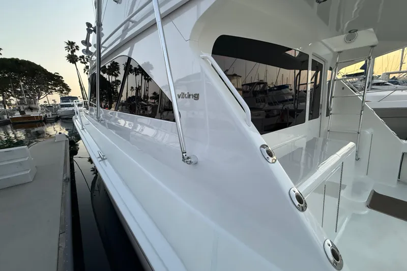 Slide: The Image of 2002 Viking 48 Convertible yacht docked at marina during sunset. - 59