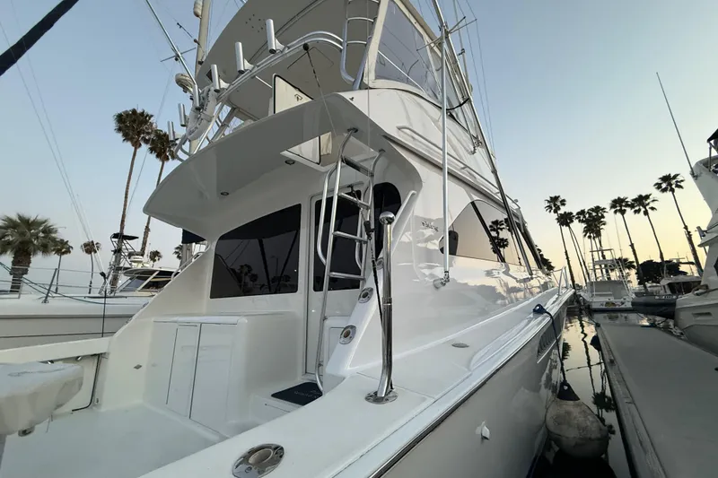 Slide: The Image of 2002 Viking 48 Convertible yacht docked, showcasing sleek design and palm trees in the background. - 60