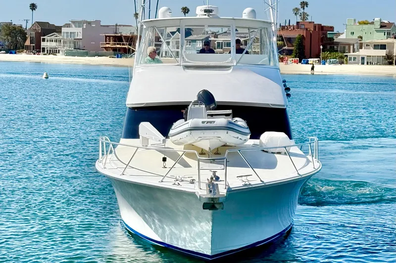 Slide: The Image of 2002 Viking 48 Convertible yacht cruising near a coastal shoreline. - 8
