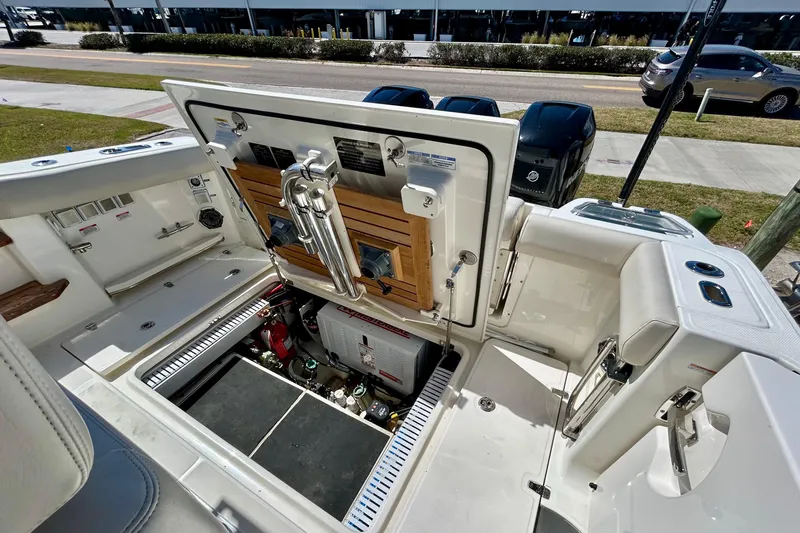 Slide: The Image of 2023 Boston Whaler 350 Realm boat interior with open storage compartment and visible equipment. - 3