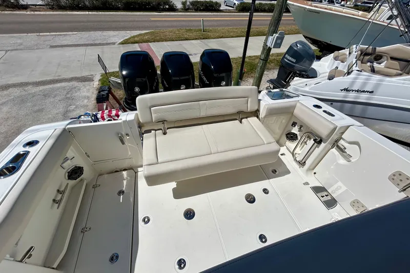 Slide: The Image of 2023 Boston Whaler 350 Realm boat deck with seating and triple outboard engines. - 7