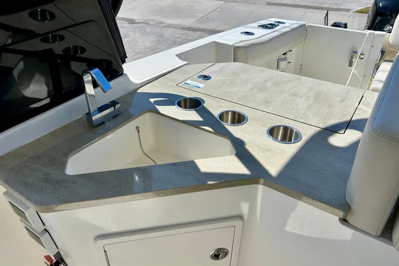 Slide: The Image of 2023 Boston Whaler 350 Realm boat sink and countertop with cup holders. - 8