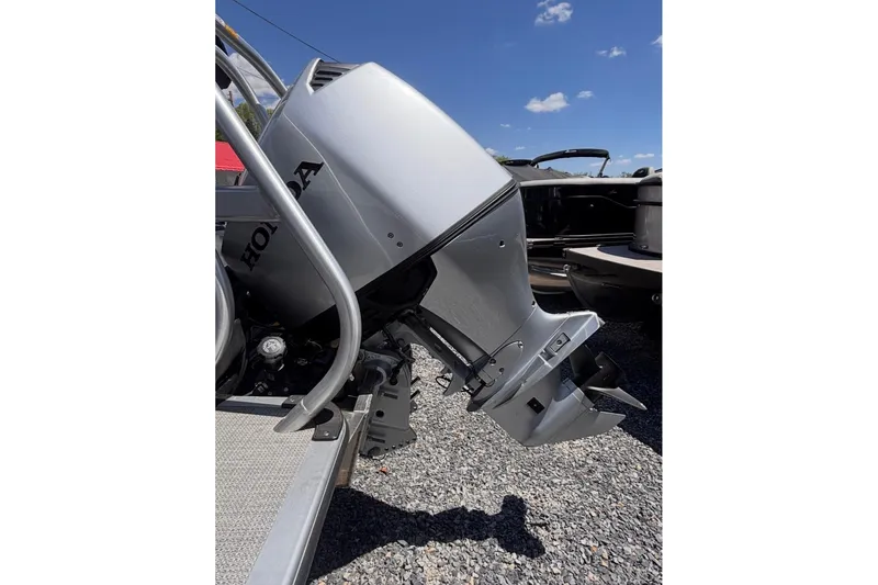 Slide: The Image of 2026 Bentley Pontoons Legacy 220 Cruise XL with Honda outboard motor, parked on gravel. - 5