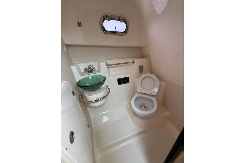 Slide: The Image of 2012 Pursuit OS 315 Offshore boat bathroom with toilet and glass sink. - 11