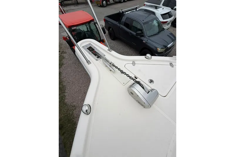 Slide: The Image of 2012 Pursuit OS 315 Offshore boat bow with anchor chain, parked near vehicles. - 13