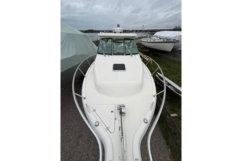 Slide: The Image of 2012 Pursuit OS 315 Offshore boat on land, showcasing sleek design and spacious deck. - 14