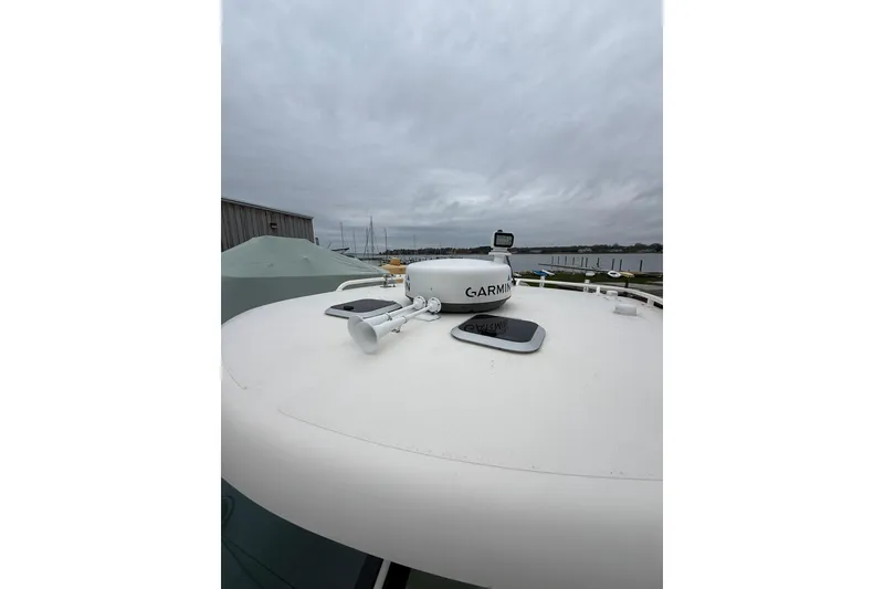 Slide: The Image of 2012 Pursuit OS 315 Offshore boat with Garmin radar on deck under cloudy sky. - 15
