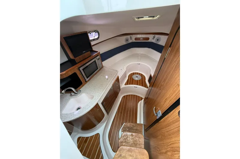 Slide: The Image of Interior of 2012 Pursuit OS 315 Offshore boat with wood accents and modern amenities. - 9