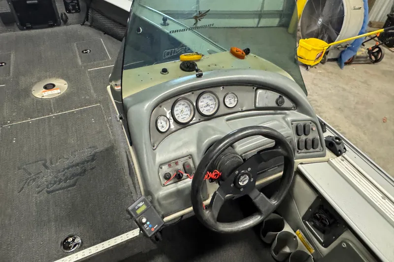 Slide: The Image of 2003 Lund 2025 Pro-V Magnum IFS boat dashboard with steering wheel and gauges. - 4