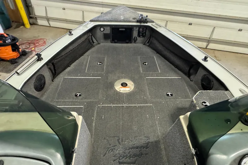 Slide: The Image of 2003 Lund 2025 Pro-V Magnum IFS boat interior with carpeted deck and storage compartments. - 5