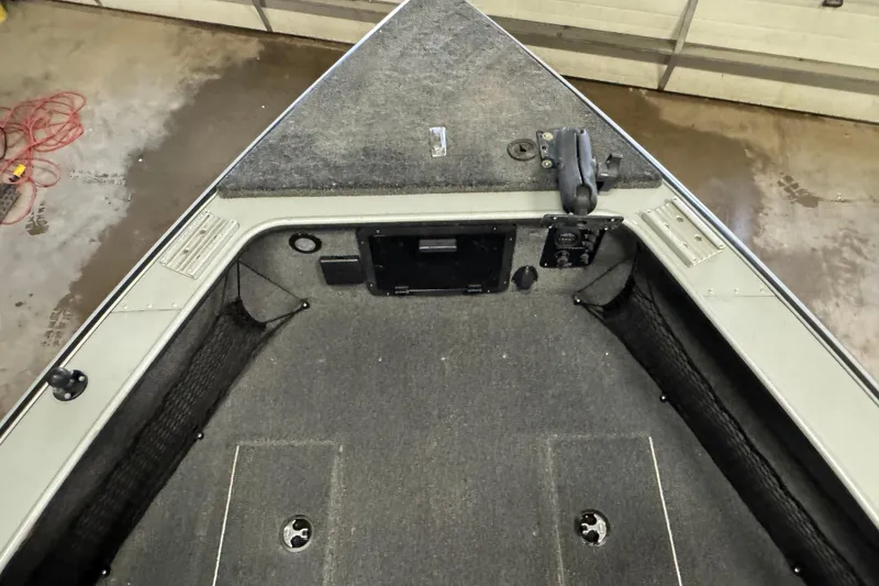 Slide: The Image of 2003 Lund 2025 Pro-V Magnum IFS boat interior with carpeted deck and storage compartments. - 6