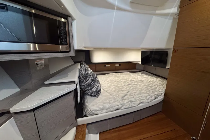 Slide: The Image of 2022 Tiara Yachts 43 LS cabin interior with bed, microwave, and modern design. - 15