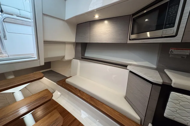 Slide: The Image of 2022 Tiara Yachts 43 LS interior with seating, microwave, and wooden steps. - 16