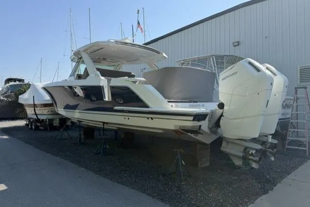 Slide: The Image of 2022 Tiara Yachts 43 LS boat with dual Mercury outboard engines, docked outdoors. - 2