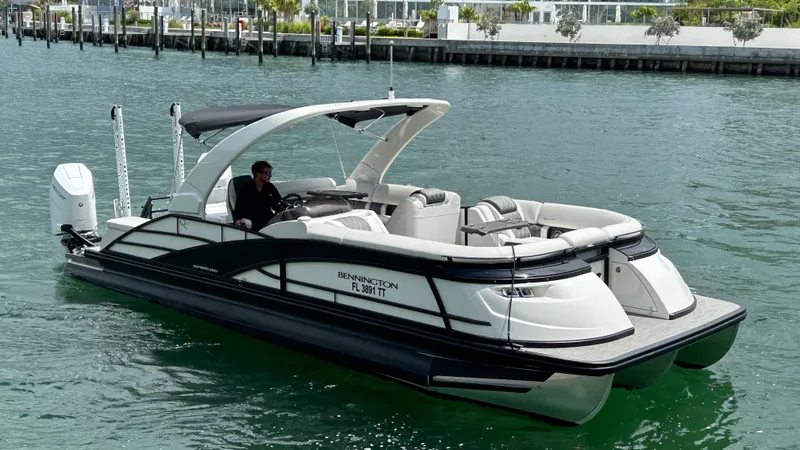 Slide: The Image of 2024 Bennington QX Line pontoon boat cruising on the water. - 10