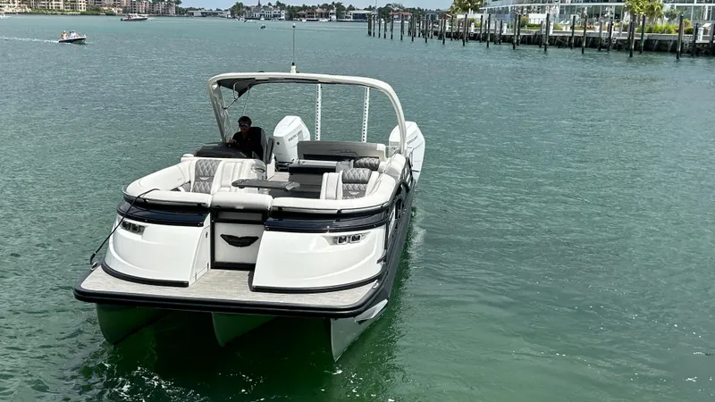 Slide: The Image of 2024 Bennington QX Line boat cruising on clear water. - 11