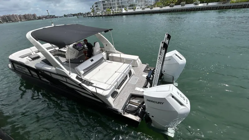 Slide: The Image of 2024 Bennington QX Line boat with Mercury engines docked in a marina. - 13