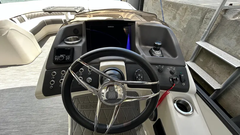 Slide: The Image of 2024 Bennington QX Line boat dashboard with steering wheel and control panel. - 15