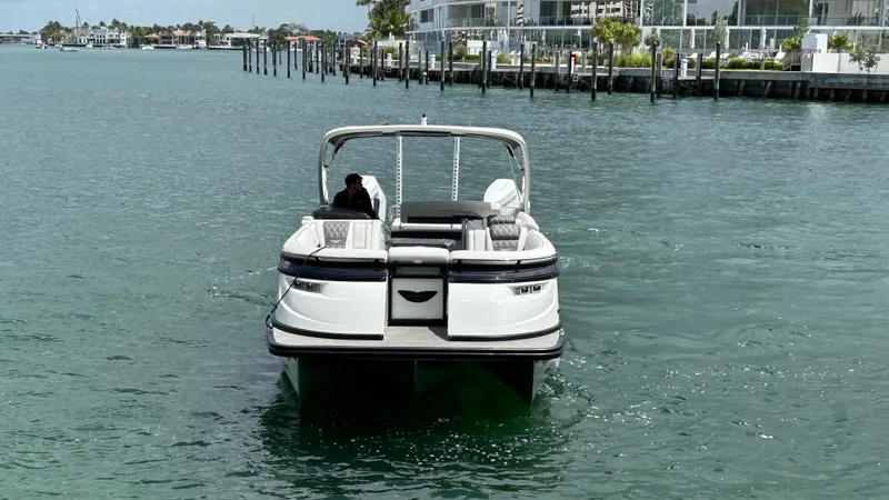 Slide: The Image of 2024 Bennington QX Line pontoon boat cruising on a calm waterfront. - 3