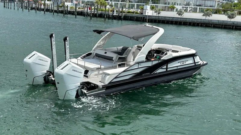 Slide: The Image of 2024 Bennington QX Line boat with twin outboard engines on the water. - 7