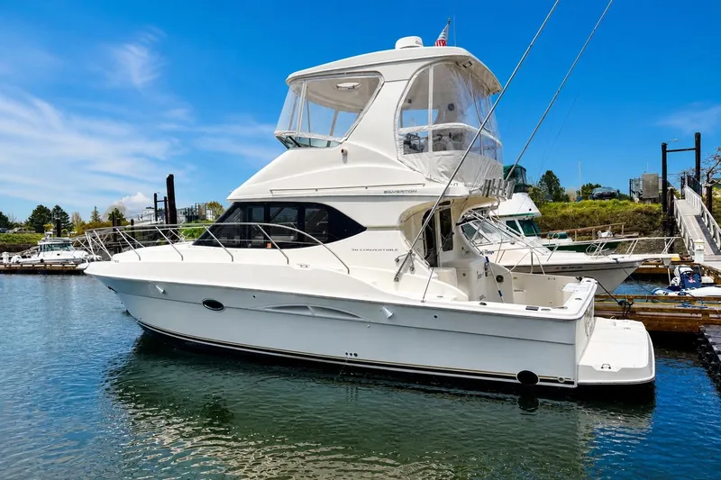 The Image of 2005 Silverton 38 Convertible yacht docked in a marina under a clear blue sky. - 0