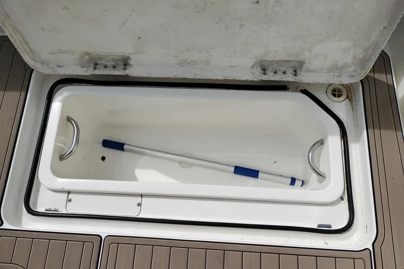 Slide: The Image of Open storage compartment on 2005 Silverton 38 Convertible boat with cleaning tool inside. - 10